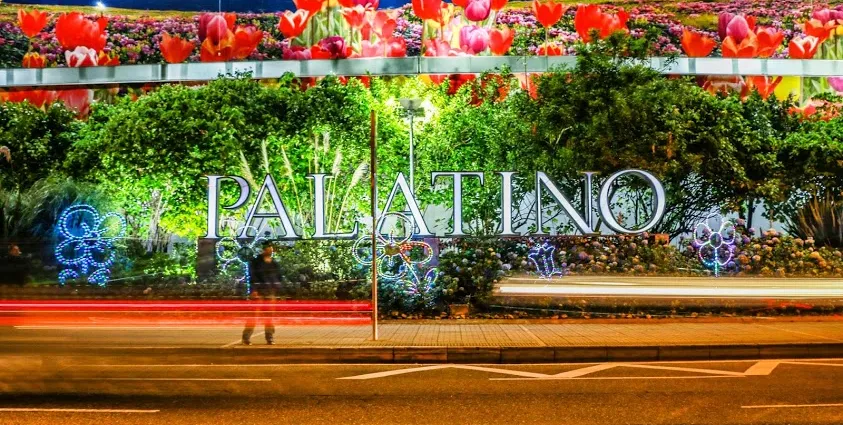 Centro Comercial Palatino: Fachada exterior nocturna iluminada con letras gigantes y flores en Bogotá